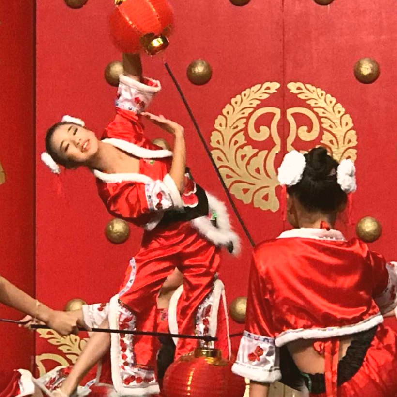 Performer leaping mid-dance holding a red lantern